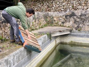 Tècnic de la Fundació Natura Parc instal·lant una plataforma salvaocells al safareig de Son Trias